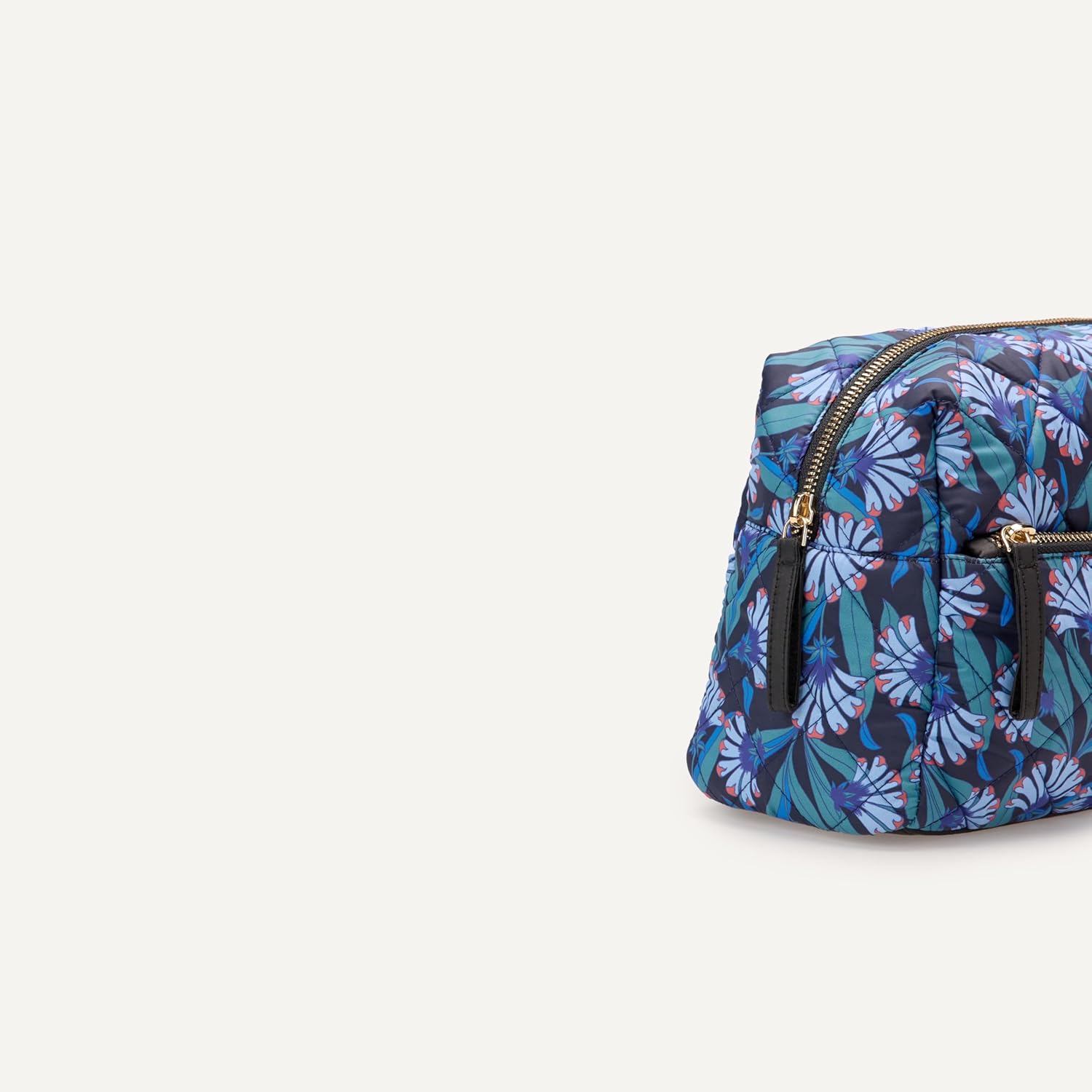 Side view of quilted floral cosmetic bag with gold zippers