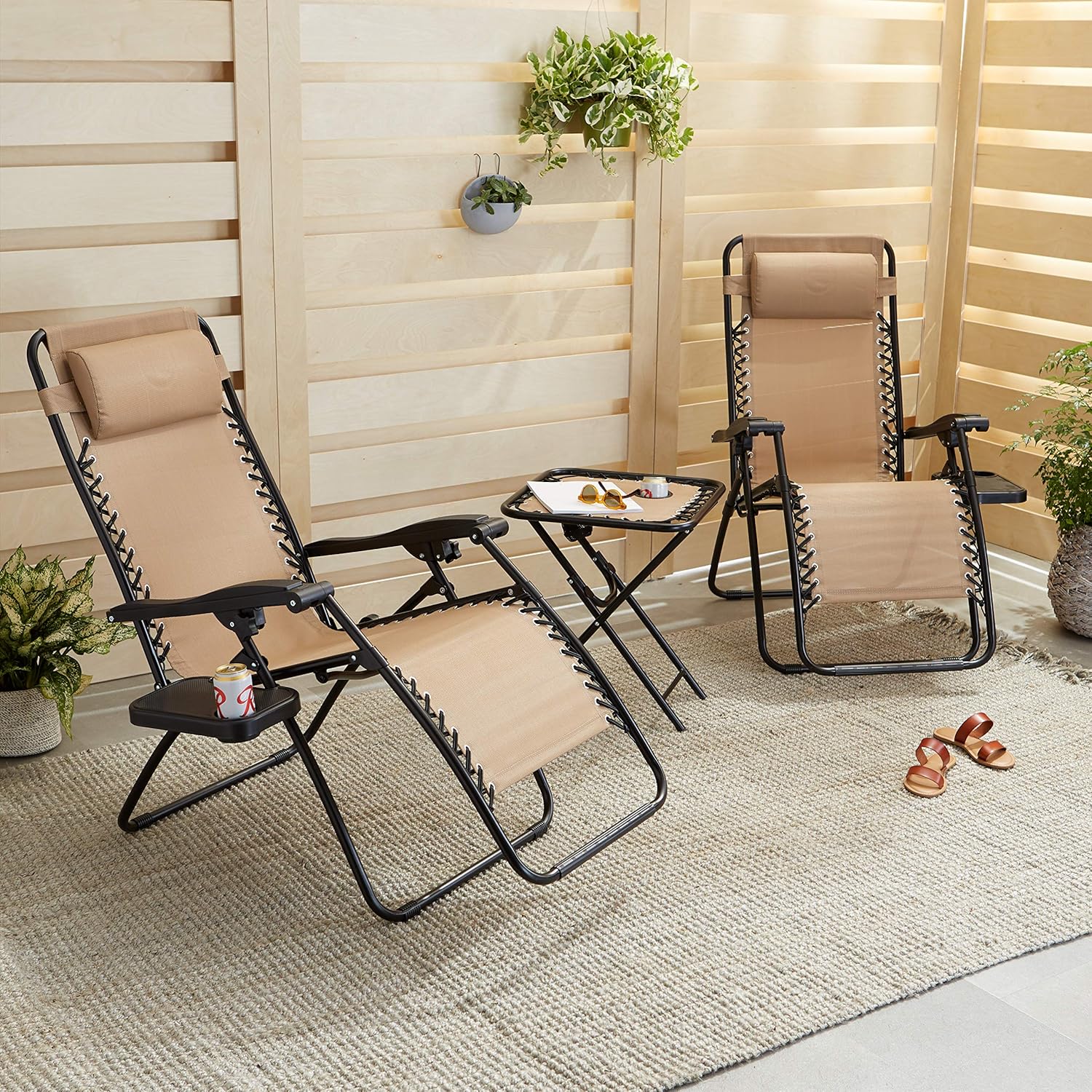 Two tan zero gravity lounge chairs with side table set