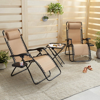Two tan zero gravity lounge chairs with side table set